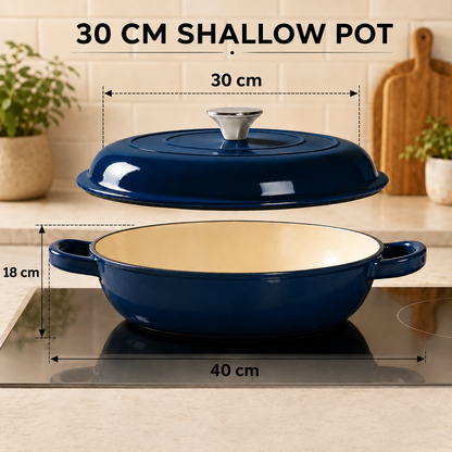 A navy blue cast-iron pot with a cream-colored interior and matching lid, shown floating above a stovetop with overlaid dimension labels reading 30 cm shallow pot, 30 cm lid width, 18 cm depth, and 40 cm pot width. Text at the top says '30 CM SHALLOW POT.